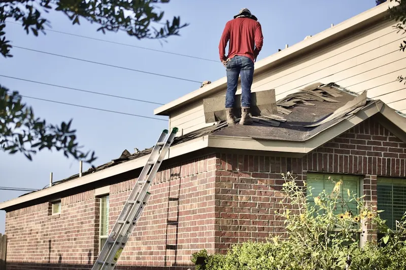 Professional roofer working on a residential roof in Louviers